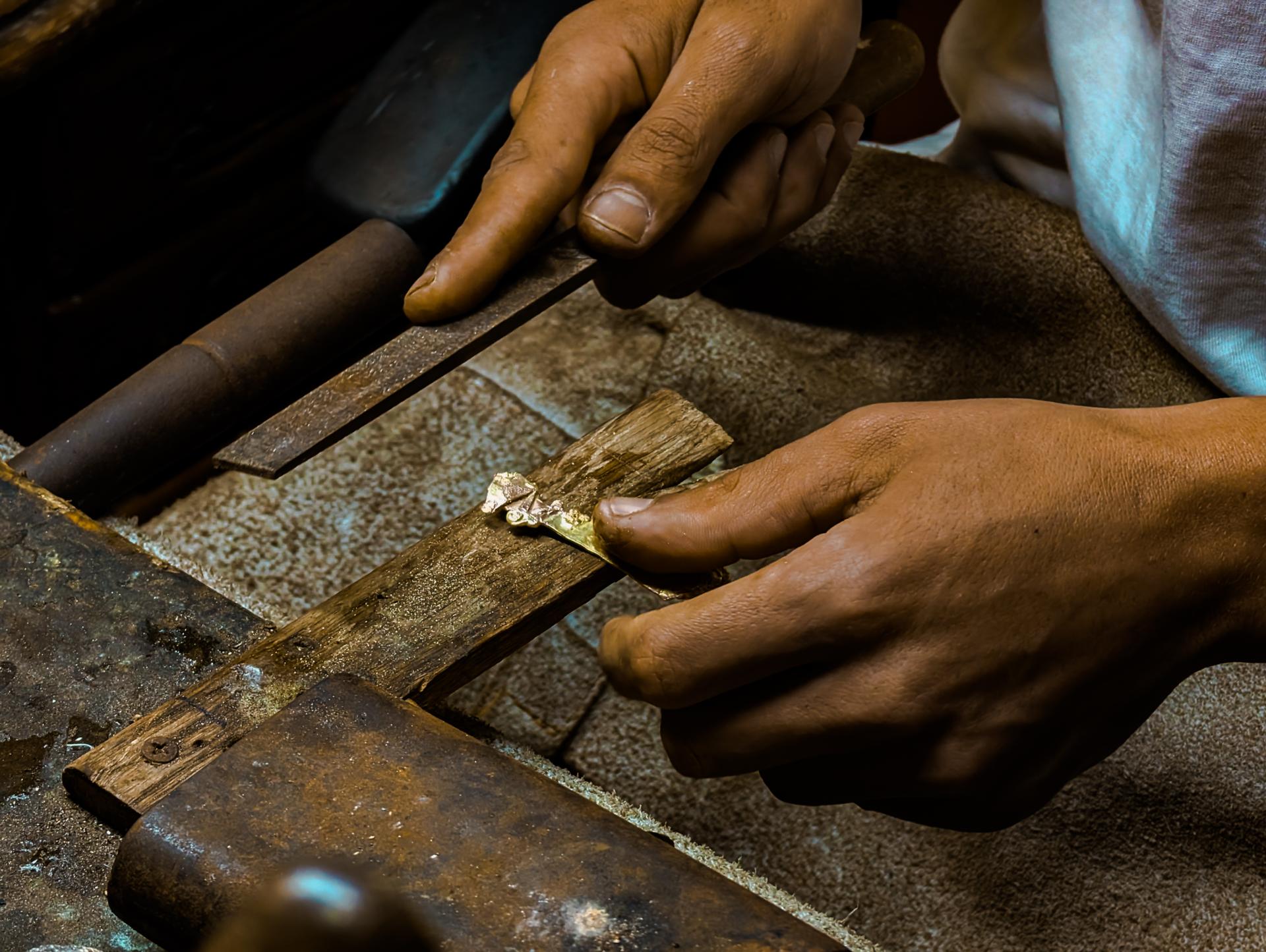Hands of a jewelry maker, working with raw bronze in Morocco