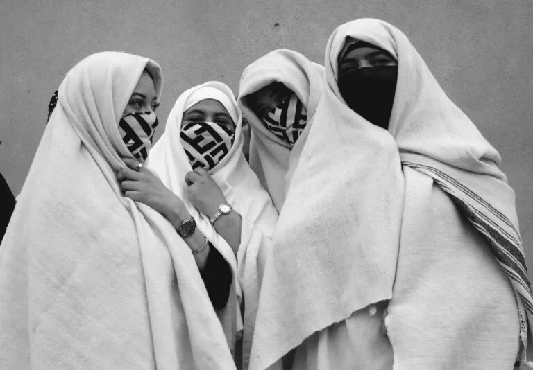 Un groupe de quatre femmes marocaines portant des vêtements traditionnels dans une rue d'Essaouira