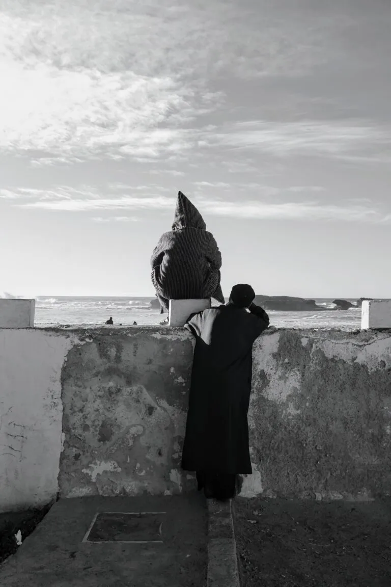 Deux hommes regardant l'océan et la plage à Essaouira