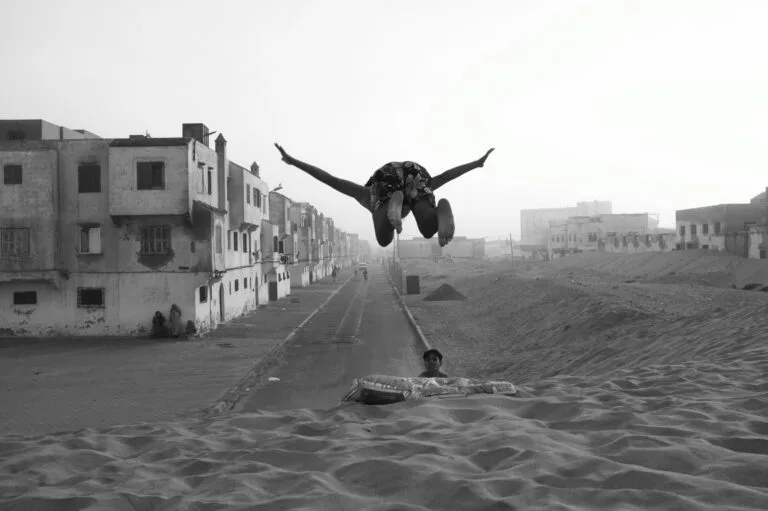 Enfants marocains sautant et jouant sur la plage d'un quartier d'Essaouira